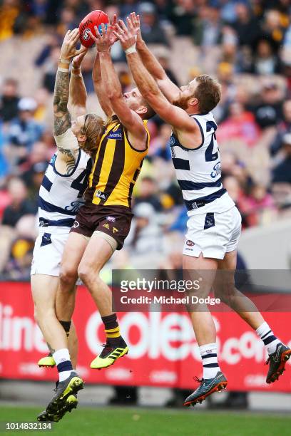 Luke Breust of the Hawks marks the ball against Tom Stewart of the Cats and Lachie Henderson of the Cats during the round 21 AFL match between the...