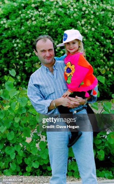 Portrait of musician Phil Collins with daughter Lily Collins, while on tour in Japan, circa 1988.
