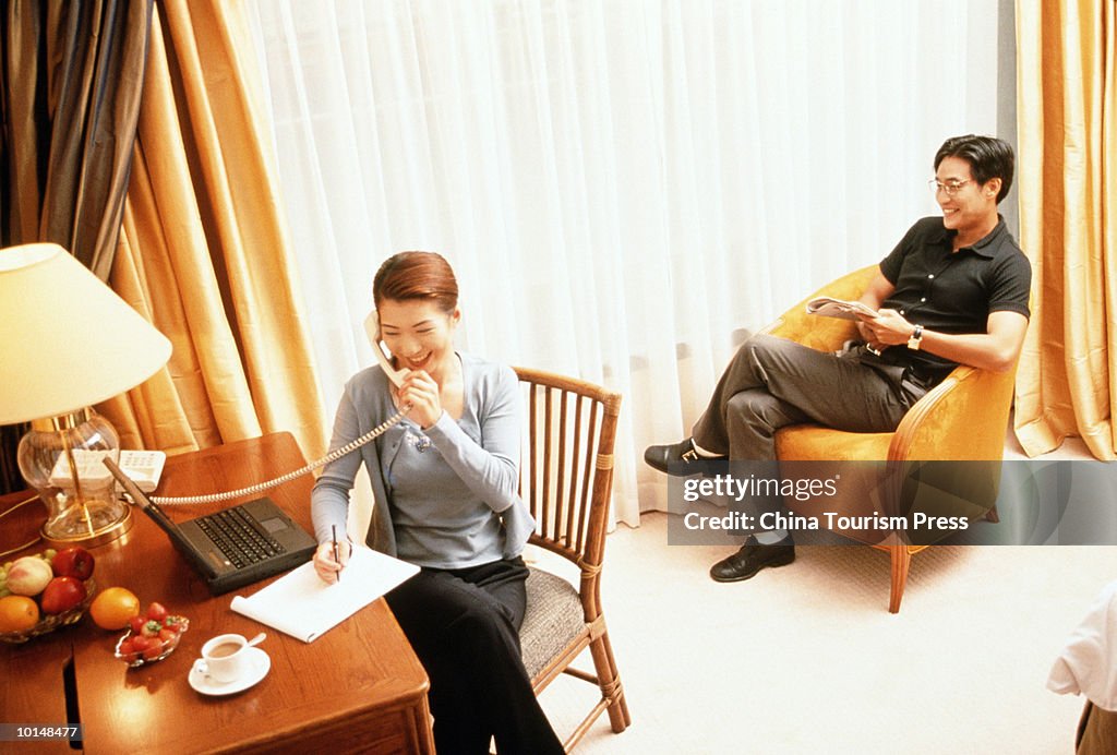 ASIAN COUPLE WOMAN ON PHONE WITH LAPTOP HONG KNOG