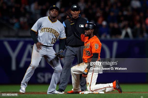 Alen Hanson of the San Francisco Giants celebrates after hitting an RBI double in front of Adeiny Hechavarria of the Pittsburgh Pirates and umpire CB...