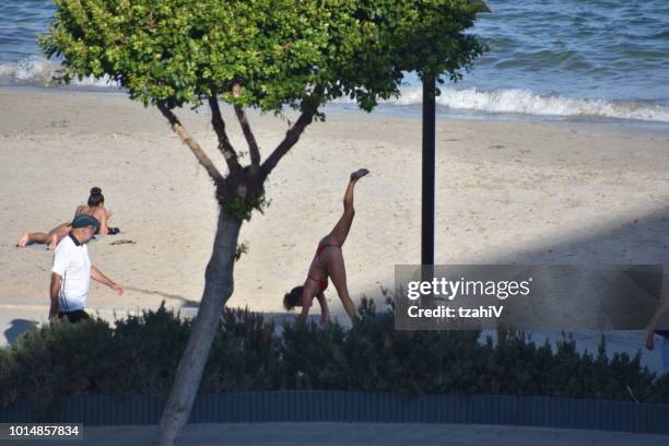 beach and sports at platja d'en bossa ibiza, spain - handstand beach stock pictures, royalty-free photos & images