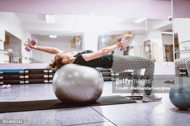 athlétique féminin travailler avec ballon de fitness dans la salle de gym - pain boule photos et images de collection