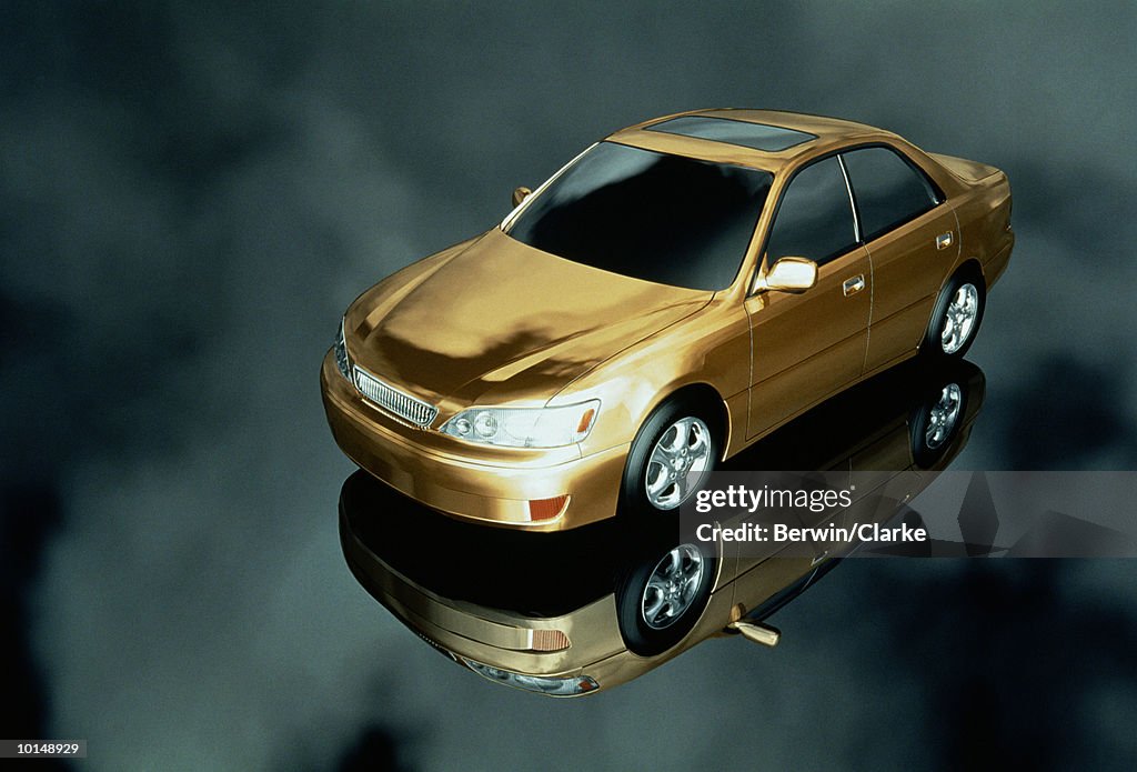 GOLD CAR ON REFLECTIVE BACKGROUND