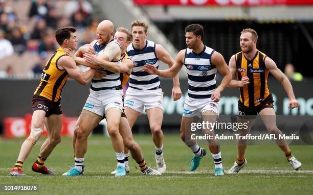 Gary Ablett of the Cats is tackled by Jaeger O'Meara and James Worpel of the Hawks during the 2018 AFL round 21 match between the Hawthorn Hawks and...