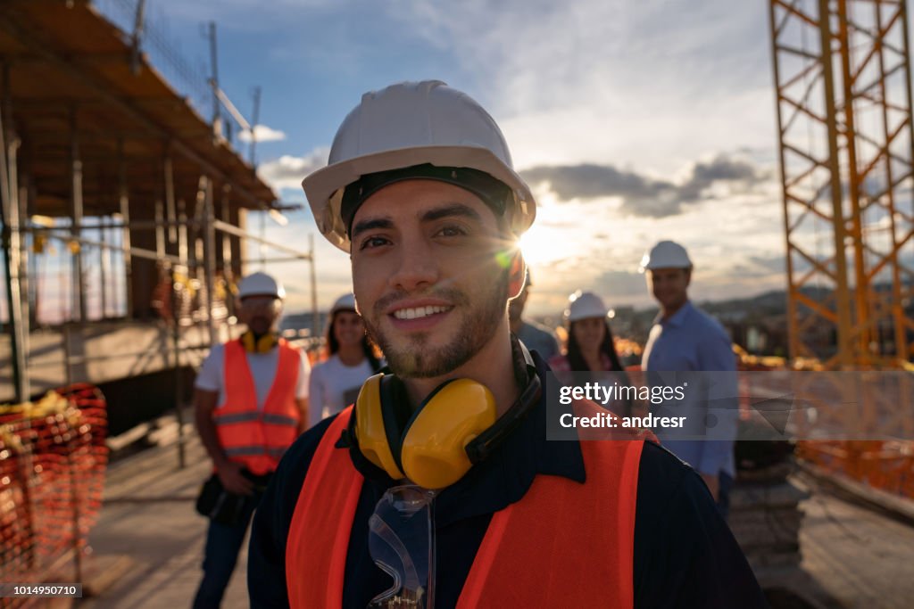 Retrato de un albañil feliz en un sitio de edificio