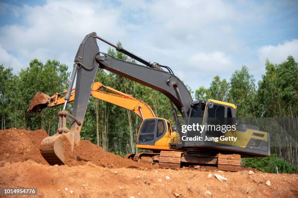 two excavator at construction site - arqueología fotografías e imágenes de stock