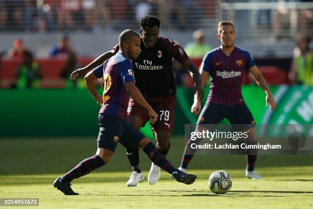 Rafinha Alcantara of FC Barcelona is defended by Franck Kessié of AC Milan during the International Champions Cup match at Levi's Stadium on August...