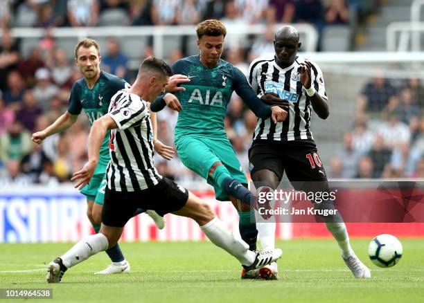 Dele Alli of Tottenham Hotspur is challenged by Ciaran Clark of Newcastle United and Mohamed Diame of Newcastle United during the Premier League...