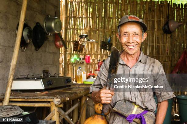 senior indonesische boer lachend portret in hut met machete - machete stockfoto's en -beelden