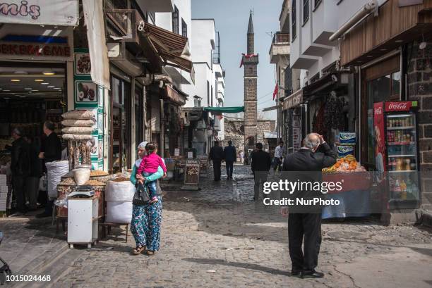 Pedestrians pass by the historic Sheikh Matar Mosque and it's four-legged minaret, which was damaged during military operations in the Sur district...