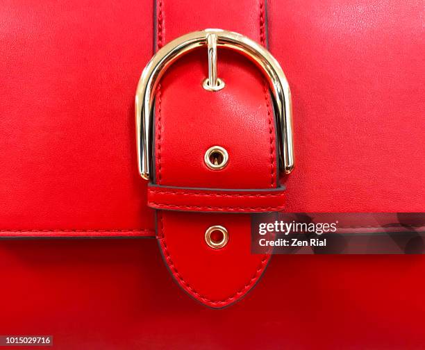 close up of a red purse detail showing belt buckle design on flap - gold belt stock pictures, royalty-free photos & images