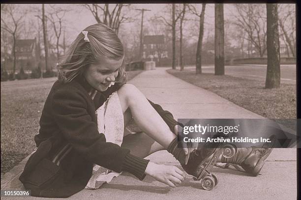 girl fastening her roller skates, 1950s - 1950s roller skates stock pictures, royalty-free photos & images