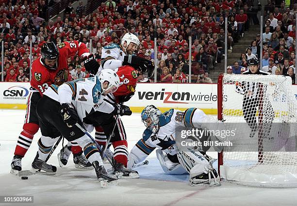 Chicago Blackhawks' Dustin Byfuglien and Jonathan Toews work to get the puck past goalie Evgeni Nabokov of the San Jose Sharks as Rob Blake and...