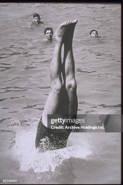 one boy diving, others swimming - diving sport stockfoto's en -beelden