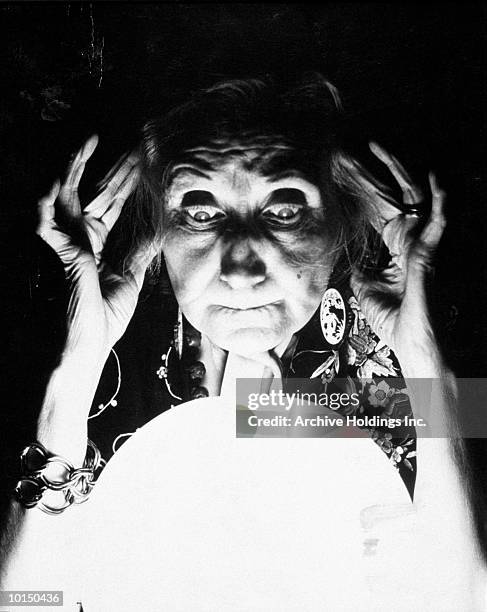 old fortune teller gazes into crystal ball - fortune telling stock pictures, royalty-free photos & images