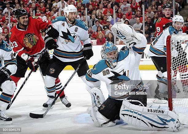 Goalie Evgeni Nabokov of the San Jose Sharks gets in position to stop the puck as Dustin Byfuglien of the Chicago Blackhawks and Rob Blake of the...