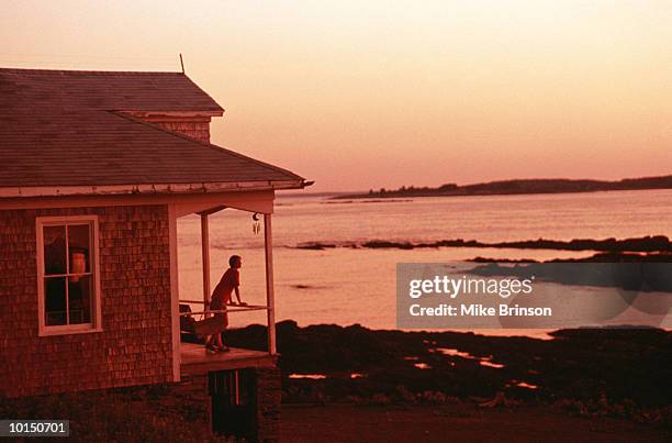 woman on porch of beach house, maine - twilight house stock pictures, royalty-free photos & images