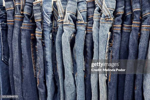 row of jeans on hangers - denim store stock pictures, royalty-free photos & images