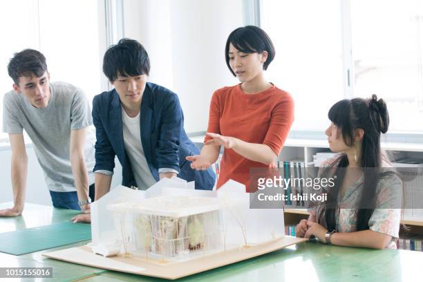 a young lady explaining the model of architecture - asain model men ストックフォトと画像