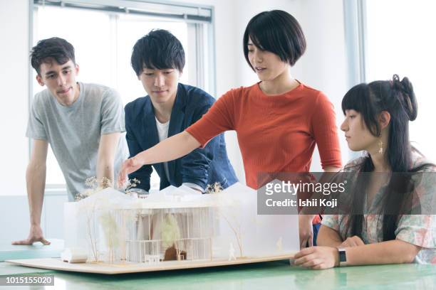 a young lady explaining the model of architecture - asain model men ストックフォトと画像