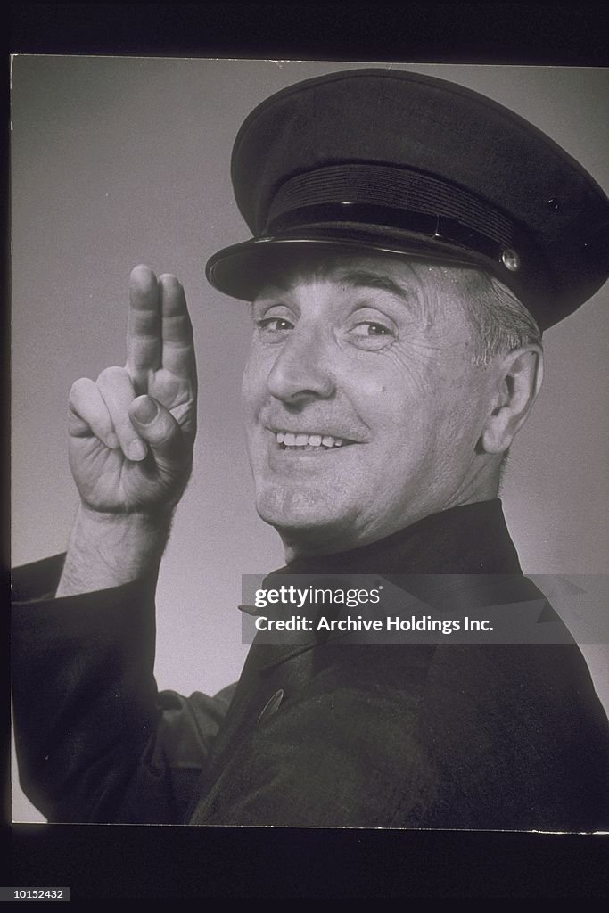 UNIFORMED MAN TAPPING HAT, CIRCA 1950S