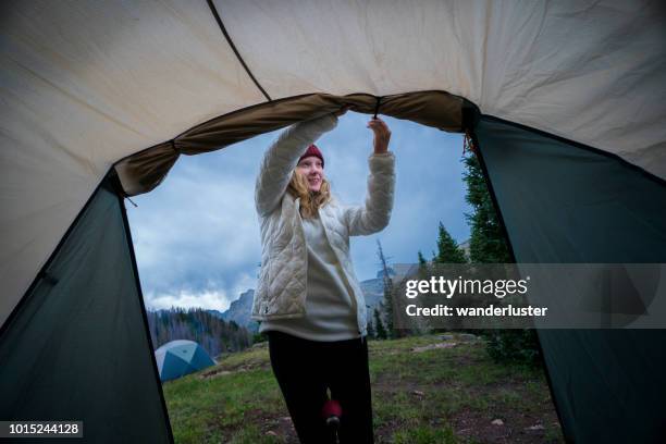 teenager-mädchen sichert schmutzfänger am zelt beim camping - fleece jacke stock-fotos und bilder