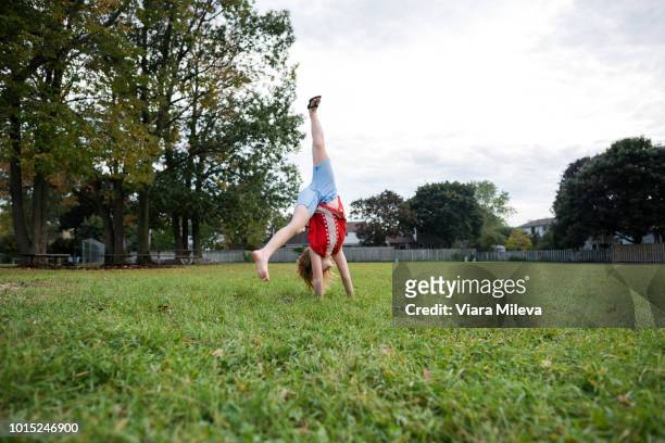 girl doing cartwheel in park - cartwheel stock pictures, royalty-free photos & images