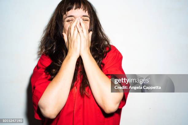 woman in red, white background - kopf in den händen stock-fotos und bilder