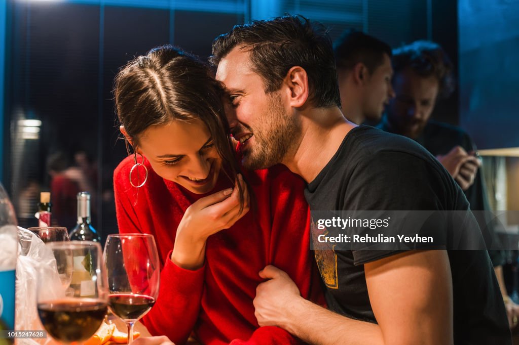 Couple drinking wine at party in apartment