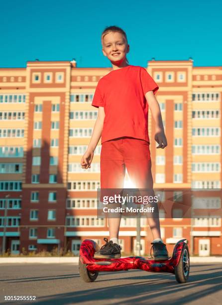 rapaz alegre depende de equilíbrio scooter - hoverboard - fotografias e filmes do acervo
