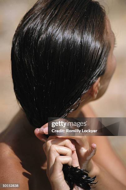 woman wringing water from hair, close-up, rear view - cabelo molhado imagens e fotografias de stock