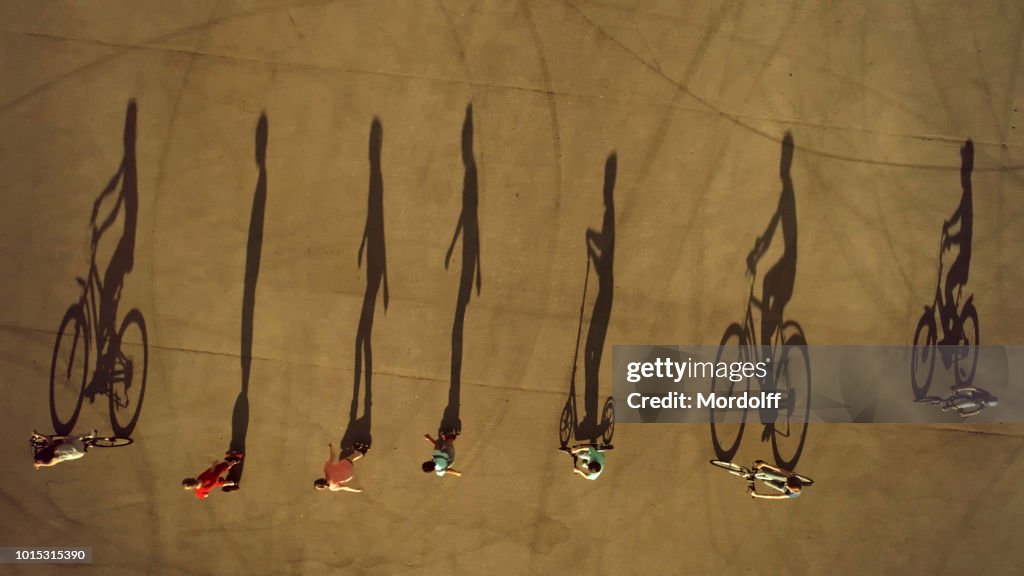 Team of Children Cast Long Shadows. Cycling, Roller Skating and Scootering