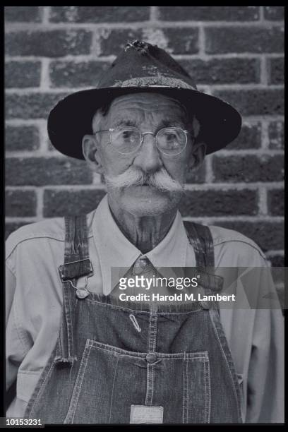 OLDER MAN WEARING OVERALLS, 1950S