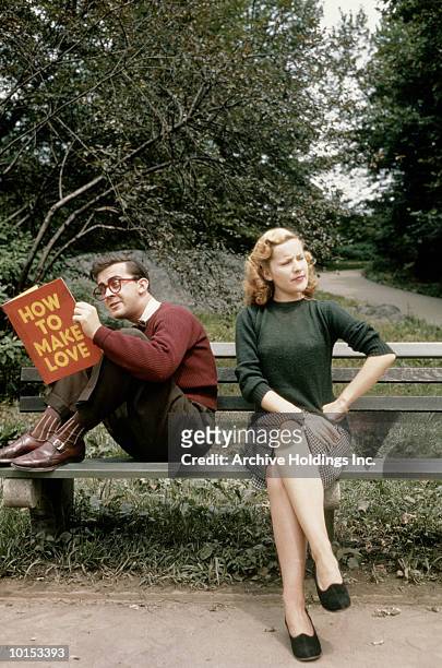 couple sitting on park bench, man reading book - angry woman vintage bildbanksfoton och bilder