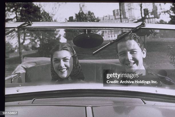 couple in front seat of convertible, circa 1950s - 1950s couple stock-fotos und bilder