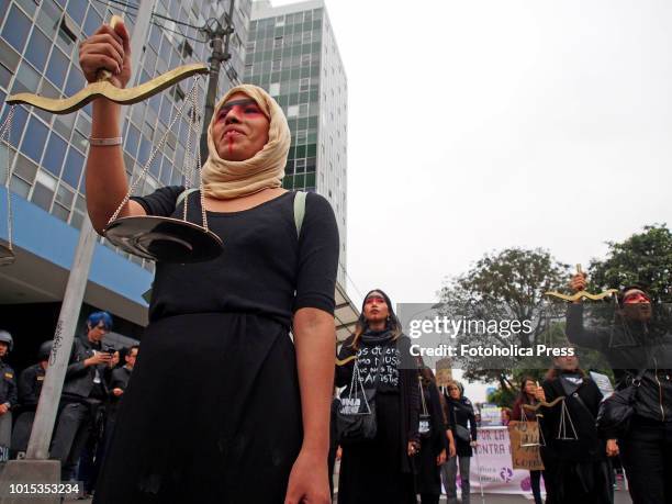 Women in black, one of them wearing a Hijab, carrying scales of justice when thousands of women from feminist and sympathetic groups take to the...