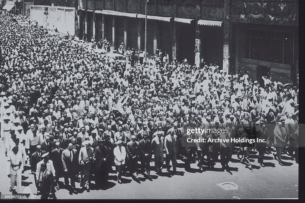 MEN MARCHING ON CITY STREET, FUNERAL, 1959