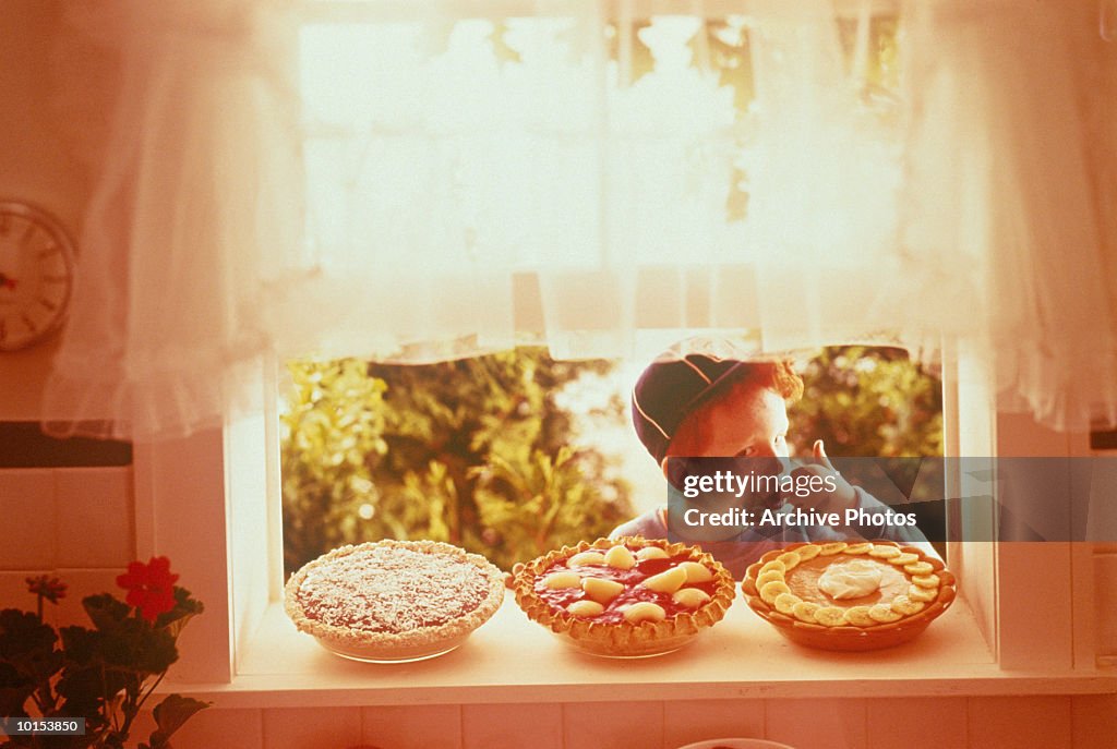 BOY TASTES ONE OF THREE PIES, 1950S