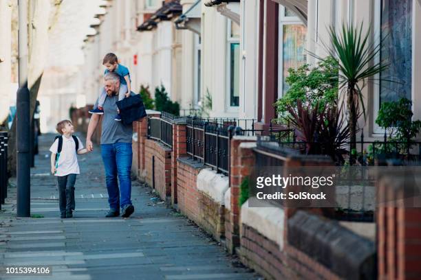 mid adult man walking with his sons - british culture walking stock pictures, royalty-free photos & images
