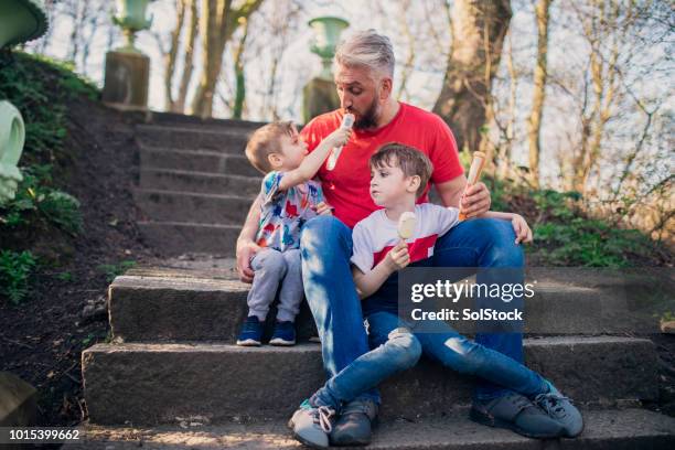 ice cream in the park with their father - family ice nature stock pictures, royalty-free photos & images