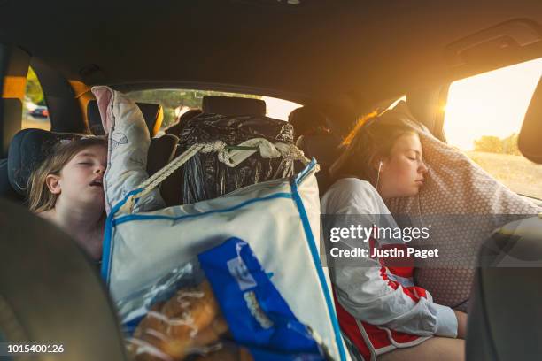 two sisters asleep on roadtrip - sleeping in car stockfoto's en -beelden