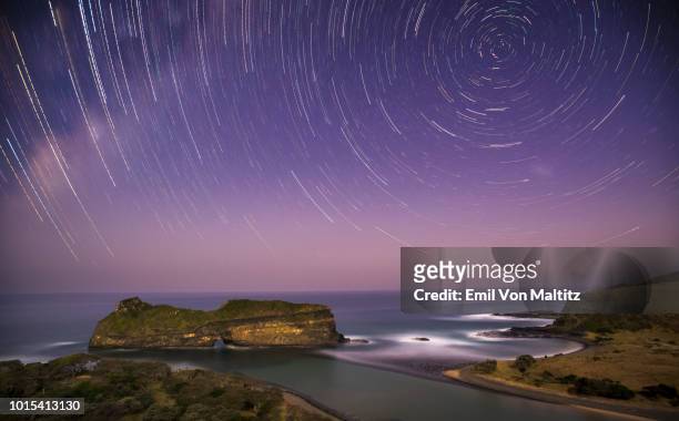 a glorious display of astrophotography at hole in the wall, coffee bay, eastern cape province, south africa. star trails; a full colour long exposure, horizontal image - hole in the wall wyoming stock pictures, royalty-free photos & images