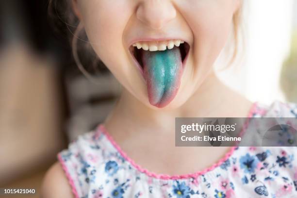 child pulling blue stained tongue - mensentong stockfoto's en -beelden