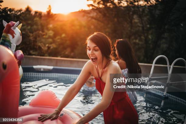 piscina di gomma per ragazze e fenicotteri - red hot summer party foto e immagini stock