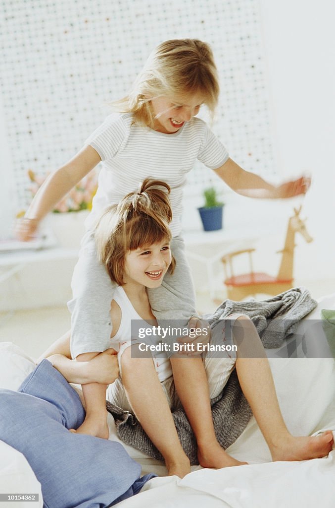 Two girls (5-9) playing on sofa