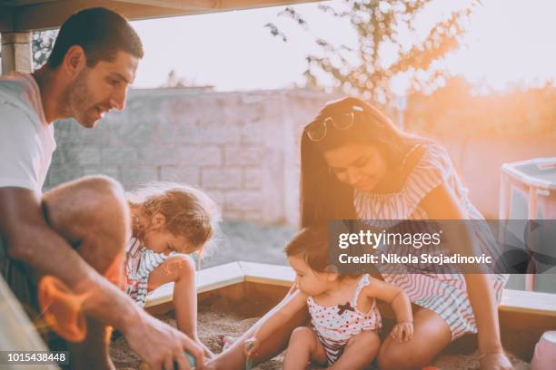 familie, spielen im sandkasten - sandkasten stock-fotos und bilder