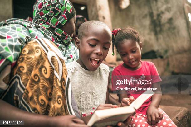 afrikanische kinder ihre hausaufgaben bei der mutter - tansania stock-fotos und bilder