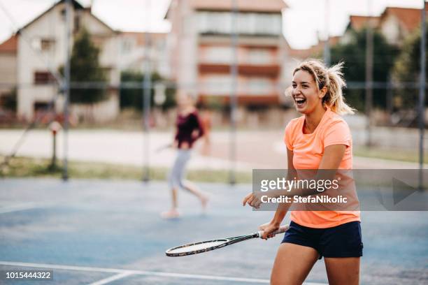 glückliche junge mädchen tennis spielen - tennis stock-fotos und bilder