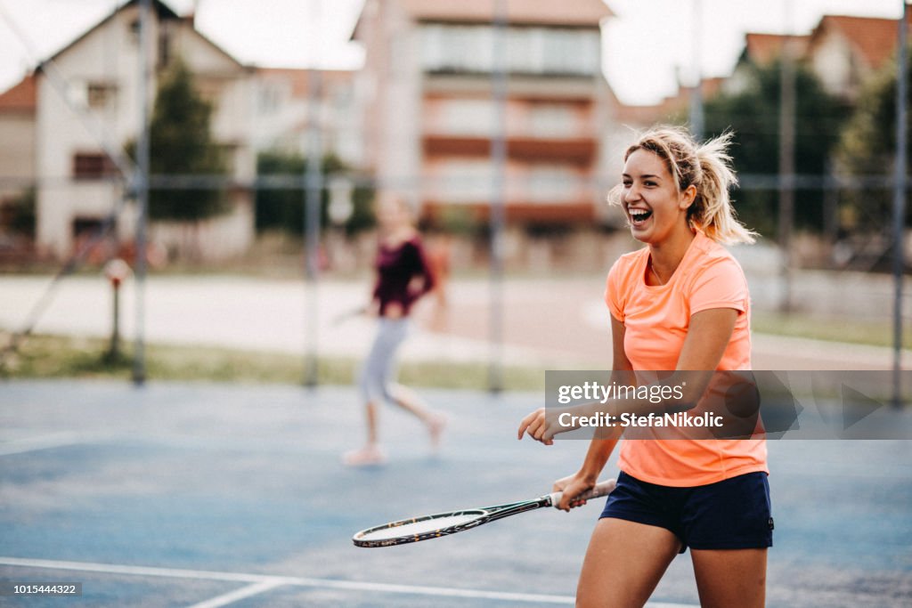 Happy young girls playing tennis