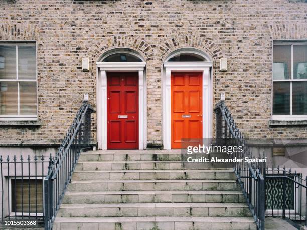 two identical red doors in dublin, ireland - twee objecten stockfoto's en -beelden